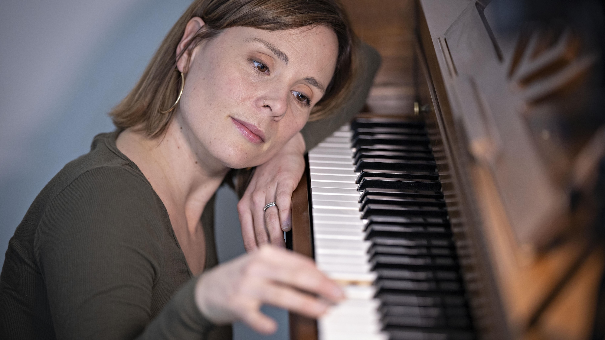 Une femme regarde sa main droite en pianotant.