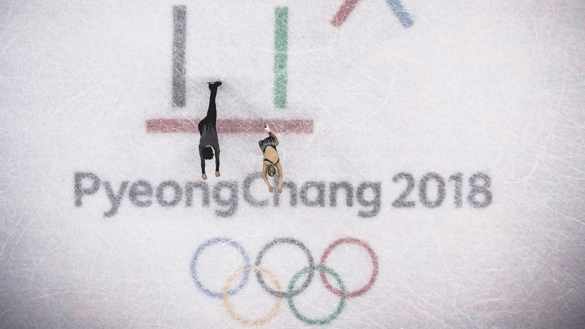 Charlie Bilodeau et Julianne Ségiun patinent sur le logo des Jeux olympiques de Pyeongchang, au centre de la patinoire.