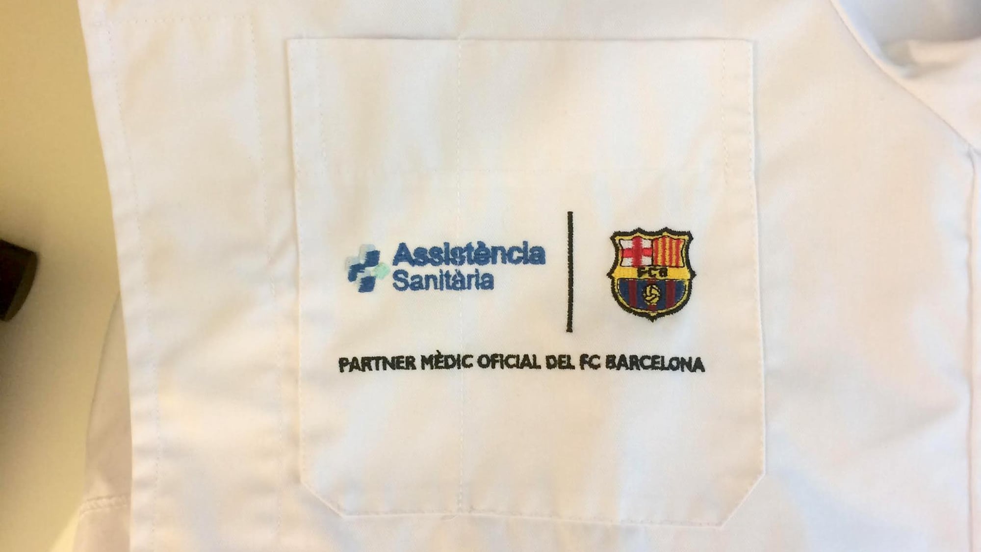 L'inscription "Partenaire médical officiel du FC Barcelone" brodée à la poche d'un sarrau.