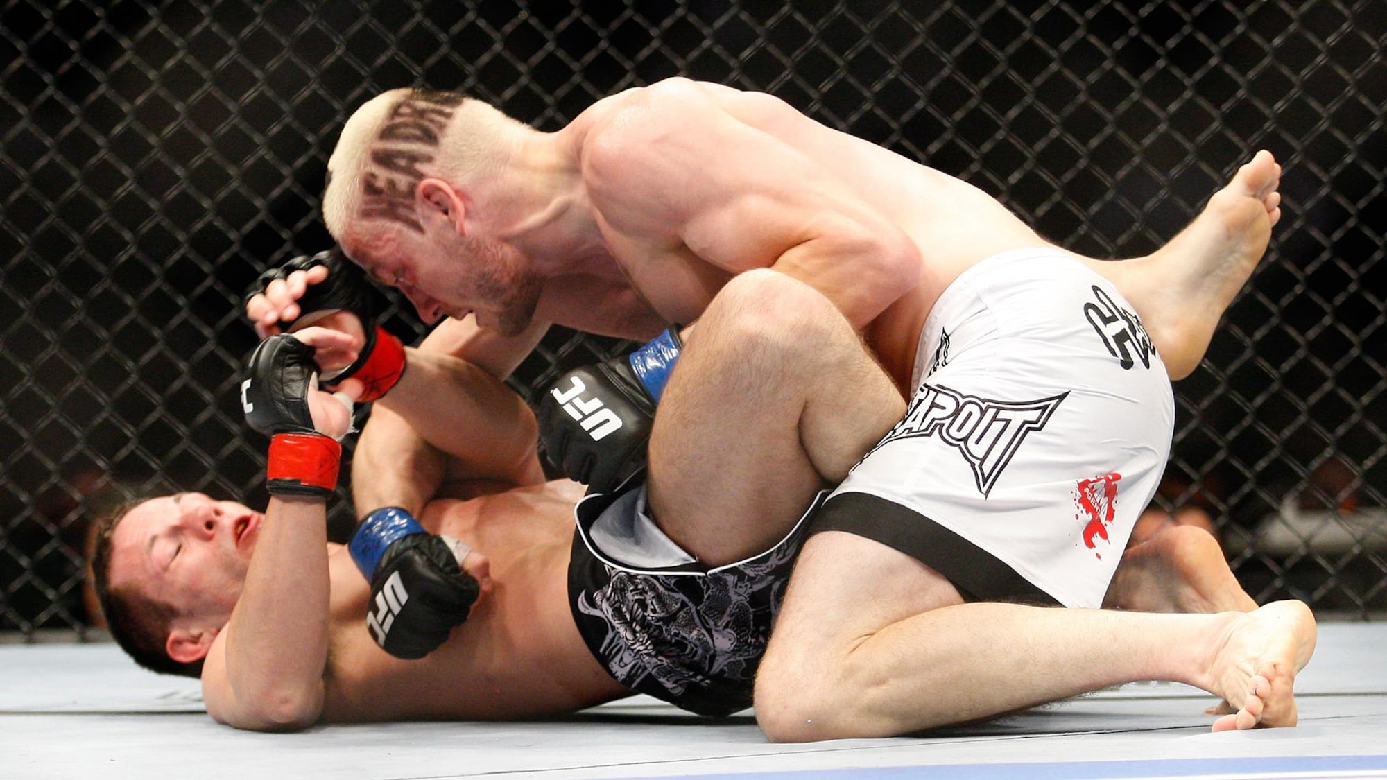 Jonathan Goulet (short blanc) frappe Marcus Davis dans un combat livré en 2010 à Montréal.