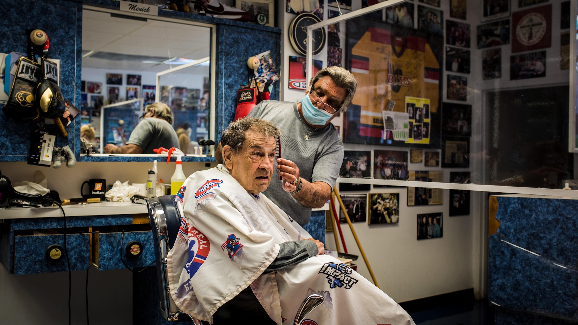 Le barbier Ménick peigne Régis Lévesque, qui y reçoit sa première coupe de cheveux depuis le début de la pandémie de COVID-19.