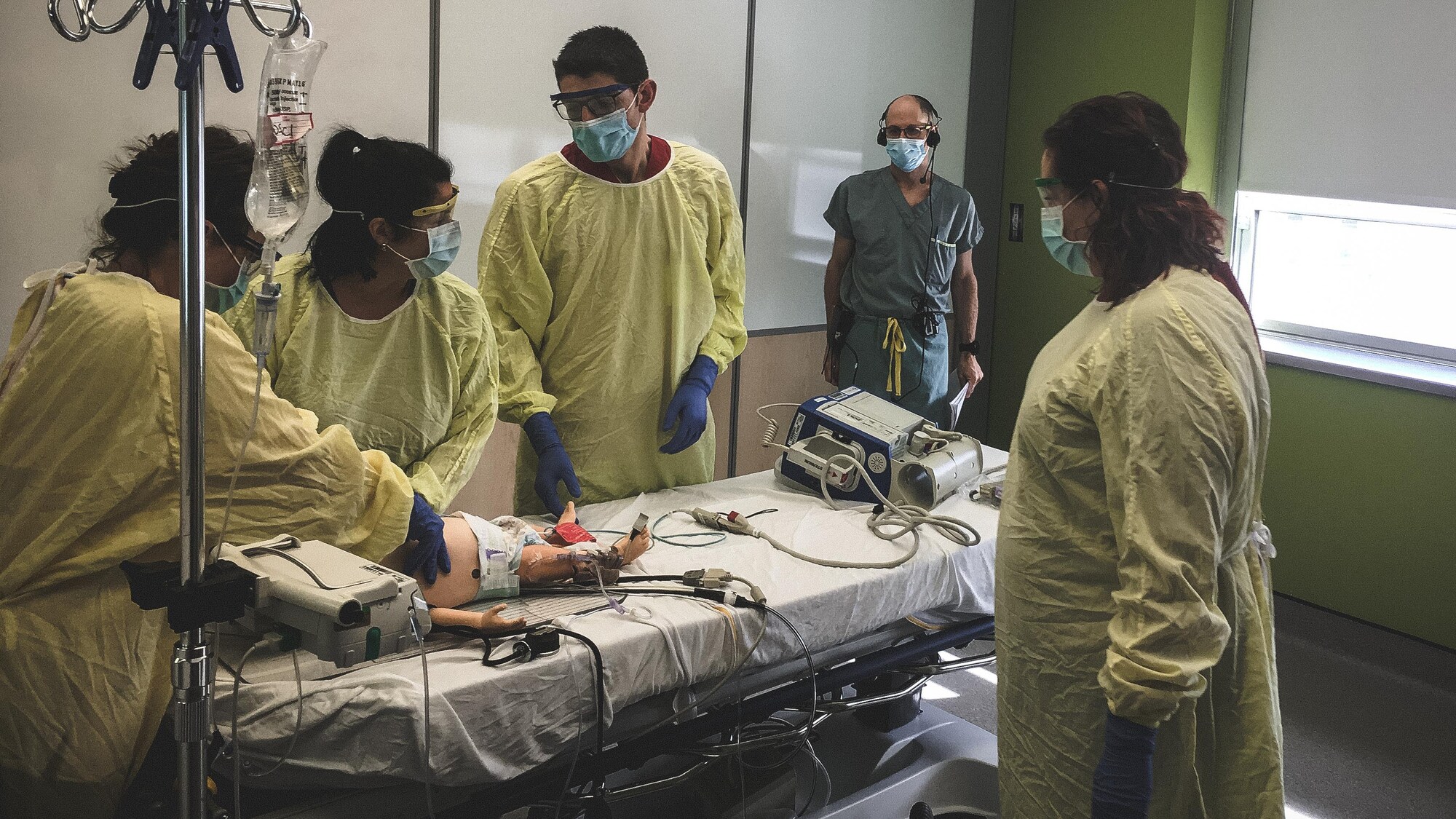 Le Dr Sébastien Roulier (au fond) supervise une simulation d'intervention auprès d'un jeune enfant, personnifié par un mannequin.