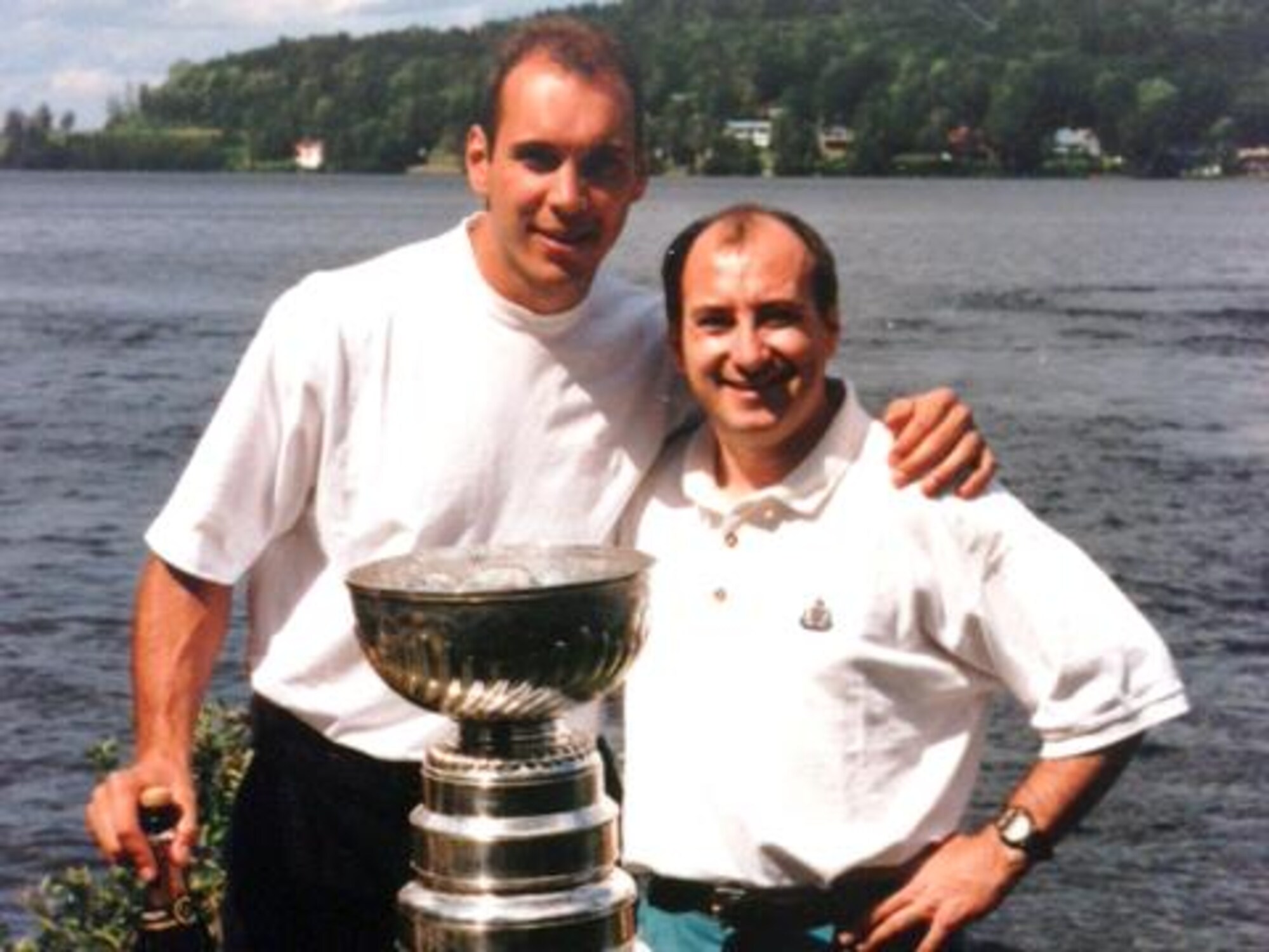 Sylvain Lefebvre et Jacques Lavergne posent derrière la coupe Stanley, devant un lac.