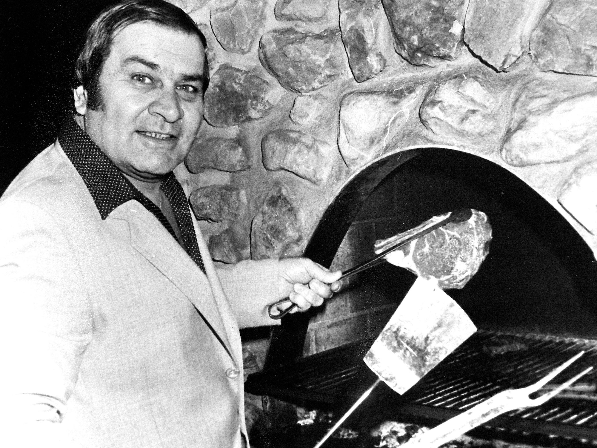 Régis Lévesque s'apprête à mettre un steak sur le grill de son restaurant.