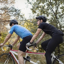 Un homme et une femme roulent sur un tandem.