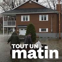 Deux maisons inondées avec une personne se déplaçant en chaloupe. 