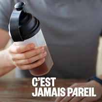 Un jeune homme tient une bouteille de type shaker dans sa main. 