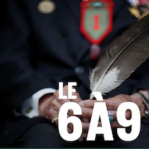 Une main tient une plume.
