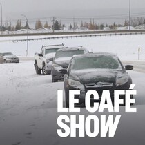 Une route enneigée avec des voitures abandonnées sorties en dehors de la chaussée.