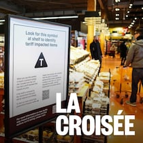 Une affiche avec le symbole « T » devant un rayon d'épicerie. 