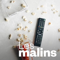 Un contenant de maïs soufflé renversé, des lunettes 3D et une télécommande.