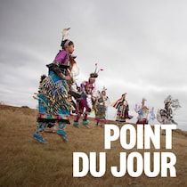 Des autochtones en tenue traditionnelle qui dansent dans un champ.