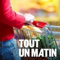 Une femme poussant un panier d'épicerie