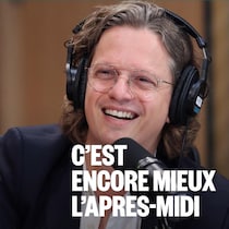 Pierre-Yves McSween, casque d'écoute sur la tête, sourit derrière un micro, dans un studio de radio.