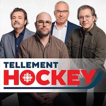 Les quatre animateurs se tiennent debout vêtu de chemises et de vestons.