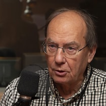 Michel Fortmann devant un micro radio dans les studios de Radio-Canada.