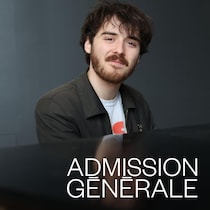Alphonse Bisaillon est assis à un piano et il sourit.