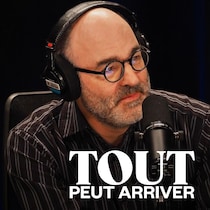 Il sourit derrière un micro.