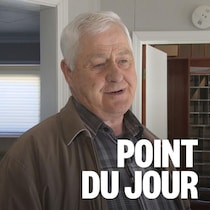 Un homme se tient debout devant une porte qui donne sur un bureau de poste.