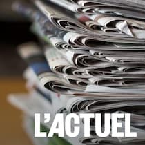 Une pile de journaux sur une table en bois.