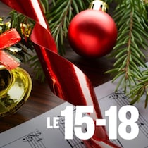 Une partition de musique est posée sur une table avec des cloches, du sapin et des boules de Noël.