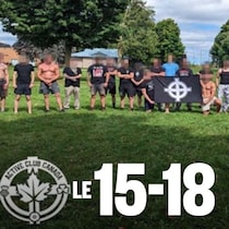 Des hommes d'un club de combat, plusieurs, torse nu, posent avec des drapeaux.