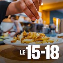 Un cuisinier prépare un plat  dans le « meilleur restaurant de poutine à Montréal ».