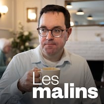 Un homme qui tient une tasse de café dans sa main.