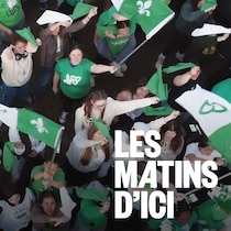 Vue de haut de plusieurs personnes qui tiennent des drapeaux franco-ontariens.