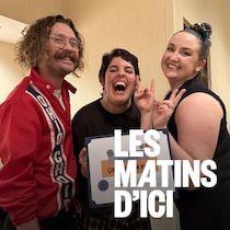 Un homme et deux femmes qui posent en souriant.