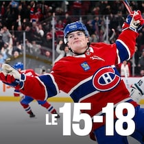 Cole Caufield lève les bras au ciel en guise de célébration.