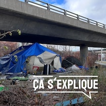 Une tente est installé dans un terrain vague sous une infrastructure routière.