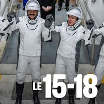 Quatre astronautes se serrent la main en souriant.