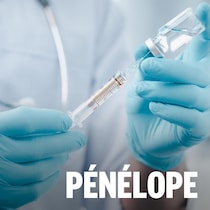 Gros plan sur des mains tenant une seringue et une fiole de vaccin.