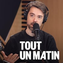 Il parle devant un micro.