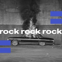 Une voiture en feu sur le bord d'une route avec le mot rock. 