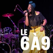 Une personne sur scène avec un micro, en train de chanter.