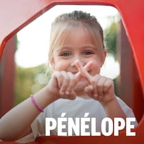 Une jeune fille fait un X avec ses doigts.