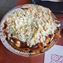 Une poutine avec de la salade de chou.
