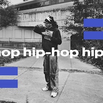 Un jeune artiste hip-hop est debut sur une structure en béton et semble manger une poutine.