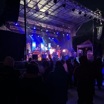 Des spectateurs devant une scène de spectacle sur laquelle on voit deux personnes.