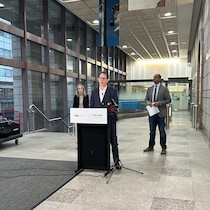 Trois personnes en conférence de presse.