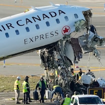Des enquêteurs près de l'appareil au cockpit arraché.