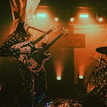 Deux musiciens jouent sur scène dans des costumes étranges. 