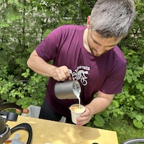 Il prépare un latte art. 