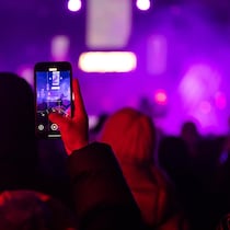 Une personne filme le spectacle avec son téléphone cellulaire.