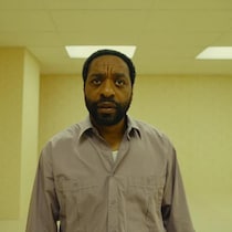 Un homme dans une salle inquiétante jaune.