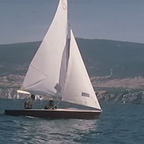 Bateau à voile avec deux passagers voguant sur le lac Okanagan.