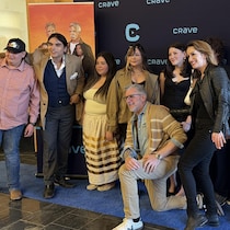 Des gens posent devant une bannière de Bon cop bad Cop lors d'une avant-première.