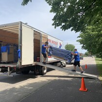 Les déménageurs portent un meuble vers un camion.